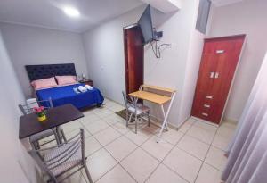 - une petite chambre avec un lit, une table et des chaises dans l'établissement Residencia Benavides, à San Vicente de Cañete