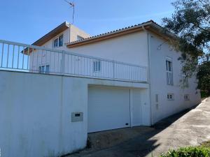 a white building with a garage and a balcony at Cantinho de Vale Maior in Penacova
