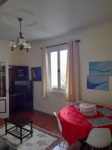 a living room with a red table and a window at Casa da Mediana in Ribeira Grande