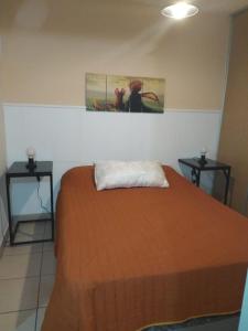 1 dormitorio con 1 cama con 2 mesitas de noche y 2 mesas en Departamento terminal Rosario en Rosario