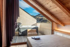 a bedroom with a bed and a balcony with a view at Spornberg Mountain Living Nordberg in Soprabolzano