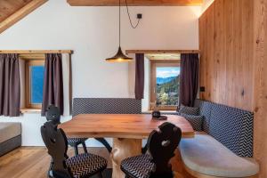 a dining room with a wooden table and chairs at Spornberg Mountain Living Nordberg in Soprabolzano