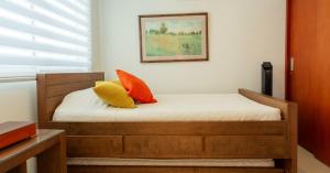 a bedroom with a bed with orange and yellow pillows at Apartamento con vista frontal al mar in Cartagena de Indias