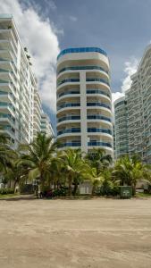 a large building with palm trees in front of it at Apartamento con vista frontal al mar in Cartagena de Indias