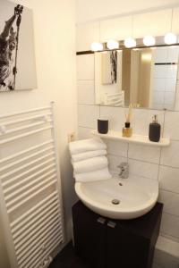 Baño blanco con lavabo y espejo en Sweet Home Apartments en Freiburg im Breisgau