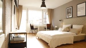 1 dormitorio con cama blanca y ventana grande en Sweet Home Apartments en Freiburg im Breisgau