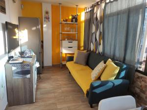 ein Wohnzimmer mit einem gelben Sofa und einem Schreibtisch in der Unterkunft montaña amarilla in Las Galletas