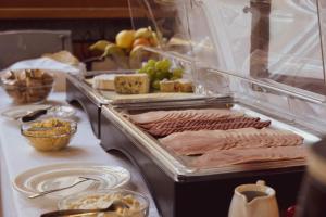 a buffet with meat and cheese and other foods on a table at Hotel Garnì Rosengarten in Pera