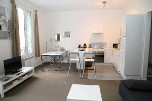 una cocina blanca con mesa y sillas en una habitación en Charmant 2 Pièces, en Honfleur