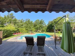 a deck with two chairs and a swimming pool at B&B L'Albatros in Fayence
