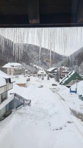 a view of a snow covered town with icicles hanging from a window at Kolakovic in Brzeće