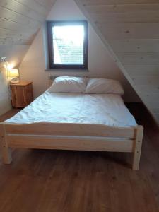 ザコパネにあるPokoje Gościnne Bachledzki Wierchのベッドルーム1室(窓のある屋根裏部屋のベッド1台付)