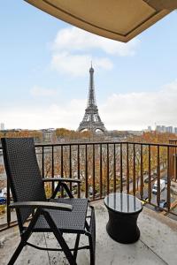 une chaise sur un balcon avec la tour Eiffel dans l'établissement CMG Tour Eiffel/ New York, à Paris