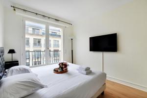 a white bedroom with a large window and a bed at CMG Tour Eiffel/ New York in Paris