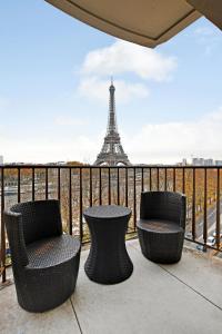 Trois chaises et une table sur un balcon avec la tour Eiffel dans l'établissement CMG Tour Eiffel/ New York, à Paris