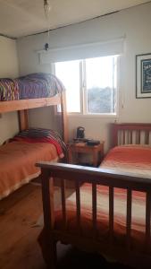 1 dormitorio con 2 literas y ventana en La Loma en La Cumbre