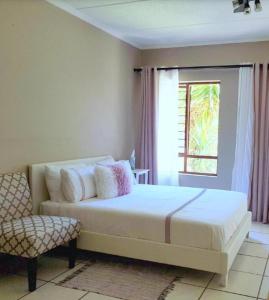 a bedroom with a white bed and a window at Samtip Sunset in Johannesburg