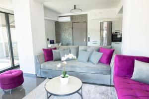 uma sala de estar com um sofá e cadeiras roxas em Luxury Penthouse with Acropolis View and Jacuzzi em Atenas