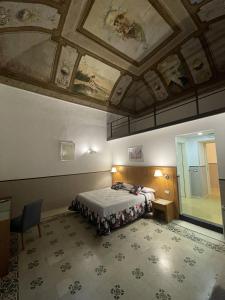 - une chambre avec un lit et un plafond orné de peintures dans l'établissement Resort CostantiNapoli 27, à Naples