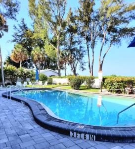 a swimming pool with a black hose around it at Sunset Beach Condo #54455 in Holmes Beach