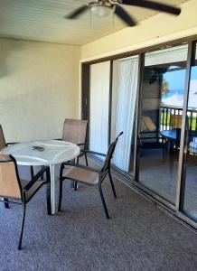 a patio with a table and chairs and a table at Sunset Beach Condo #54455 in Holmes Beach