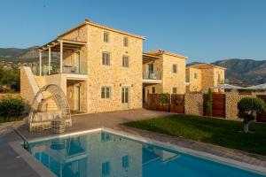 a villa with a swimming pool in front of a house at Katergo Luxury Villas in Stoupa
