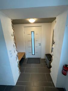 a hallway with a white door and a tile floor at Dambach Appartement in Rossleithen