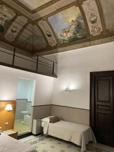 Cette chambre comprend 2 lits et un plafond. dans l'établissement Resort CostantiNapoli 27, à Naples