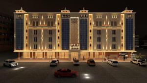 阿可贺巴تمايا للشقق الفندقية的一座大楼，前面停满了汽车