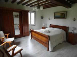 una camera con un grande letto e una sedia di Gîte des Bois Rimbert a Beuzeville