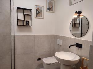 bagno con lavandino, servizi igienici e specchio di casa GARDA a Garda
