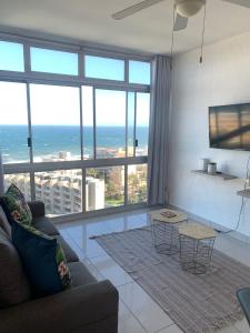 a living room with a view of the ocean at Aziel by the Sea in Ballito