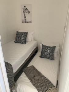 2 Einzelbetten in einem kleinen Zimmer mit Röcken in der Unterkunft Aziel by the Sea in Ballito