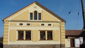 Una gran casa amarilla con ventanas en la parte superior. en Pension Smetanuv statek, en Hradec Králové