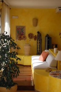 a bedroom with a bed and a yellow wall at El Mosaico Del Sol in Lampedusa