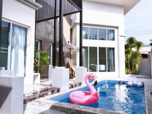 a pink flamingo in a swimming pool in front of a house at Nadda Pool Villa Ranong in Ban Bang Rin (1)