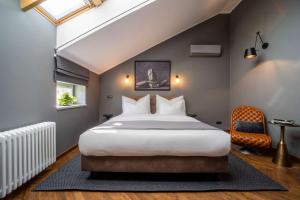 a bedroom with a large bed and a chair at The Viaduct - Suites & More in Prague