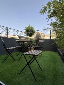 un patio con mesa y sillas en el césped en Flamenco modern & luxury, en Málaga