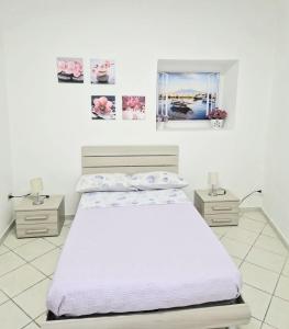 ナポリにあるANDREA'S HOUSEの白いベッドルーム(ベッド1台、ナイトスタンド2台付)