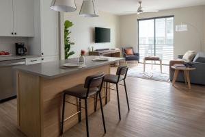 a kitchen and living room with a large island with stools at Sentral Old Town in Scottsdale