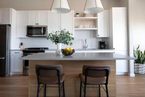 a kitchen with a large island with two bar chairs at Sentral Old Town in Scottsdale