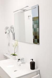 een badkamer met een witte wastafel en een spiegel bij Casa del Telegrafo in Utrera