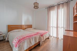 a bedroom with a bed and a large window at Villa Familia Dehoux in Camacha