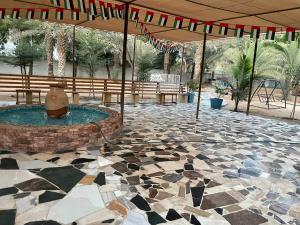 a patio with a fountain and a stone floor at Big Guest House - استراحة كبيرة in Al Ḩamīdīyah