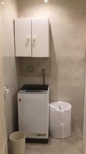 a small kitchen with a white refrigerator and a trash can at Big Guest House - استراحة كبيرة in Al Ḩamīdīyah