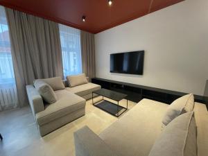 - un salon avec deux canapés et une télévision à écran plat dans l'établissement Apartamenty Jezuicka 16, à Bydgoszcz