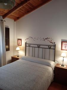 a bedroom with a large bed with two lamps at Apartamentos El Brezo in Albarracín