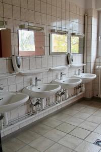 a bathroom with four sinks and two mirrors at AUBERGE DE JEUNESSE in Colmar