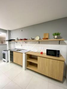 - une cuisine avec un comptoir et un four micro-ondes dans l'établissement Apartamento de 01 quarto, novíssimo, em Ipiabas., à Barra do Piraí