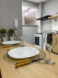 - une table avec une assiette et 2 verres à vin dans l'établissement Apartamento de 01 quarto, novíssimo, em Ipiabas., à Barra do Piraí